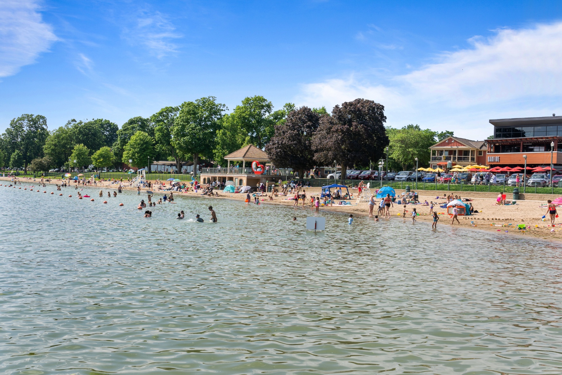 Riviera Beach panorama with swimmers, sunbathers and Oakfire restaurant